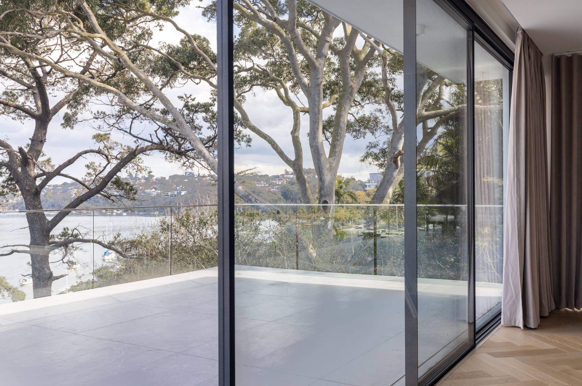 Floor-to-ceiling SLEEK sliding doors opening onto a treetop terrace